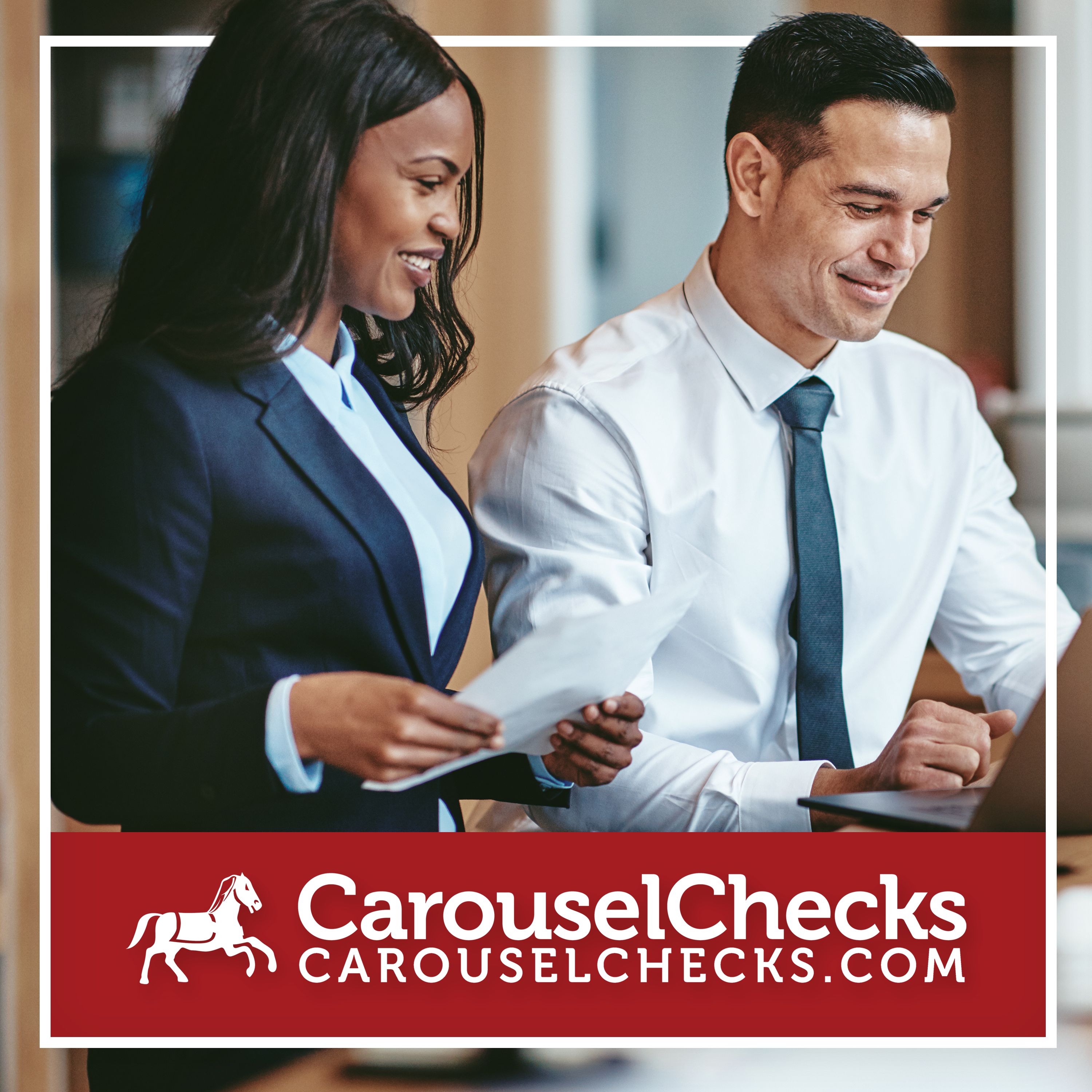 Two professionals in business attire are smiling while reviewing documents together at a desk, with a laptop nearby, conveying collaboration and productivity. The image is framed with a clean border and features a bold red banner at the bottom displaying the Carousel Checks logo and website.